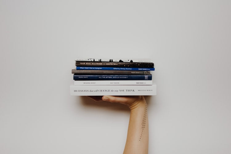 hand holding a stack of books