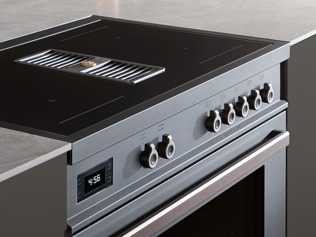 induction bertazzoni air tec in carbonion nestled between slate counters in a kitchen