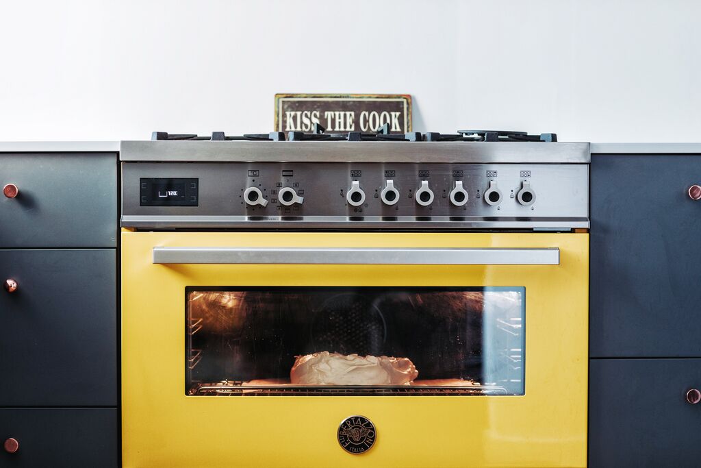 Dual fuel bertazzoni professional series cooker in yellow baking food inside the oven
