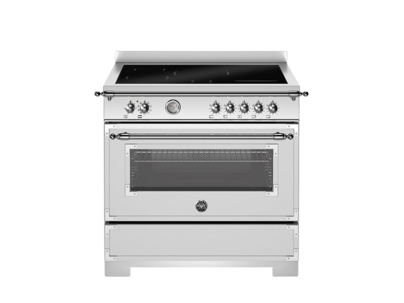 Stainless steel kitchen range with black cooktop on a white background