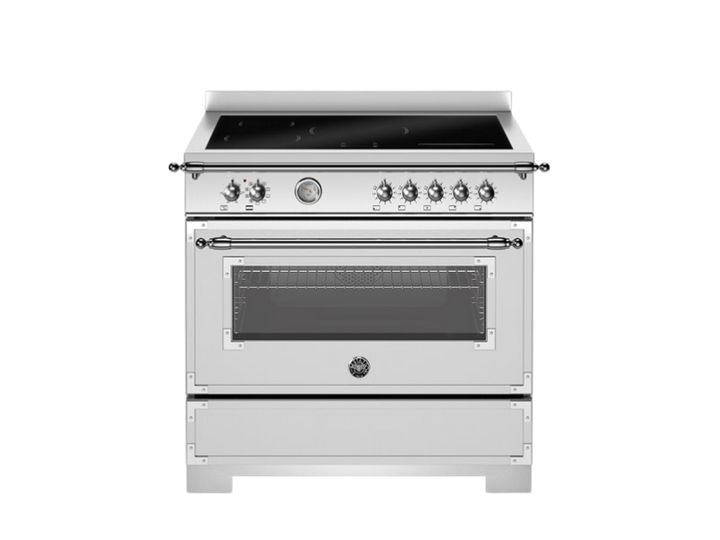 Stainless steel kitchen range with black cooktop on a white background