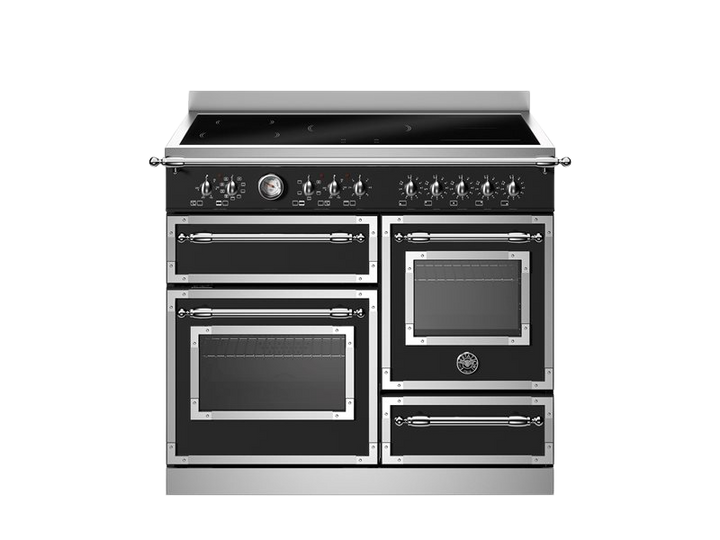 Stainless steel kitchen range with multiple ovens on a white background