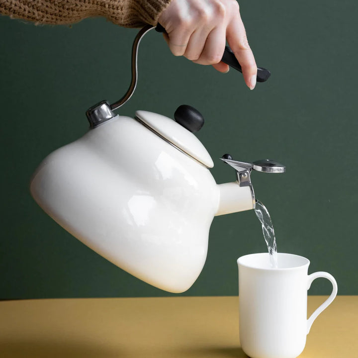 la cafetiere steel whistling kettle in cream pouring water into a mug