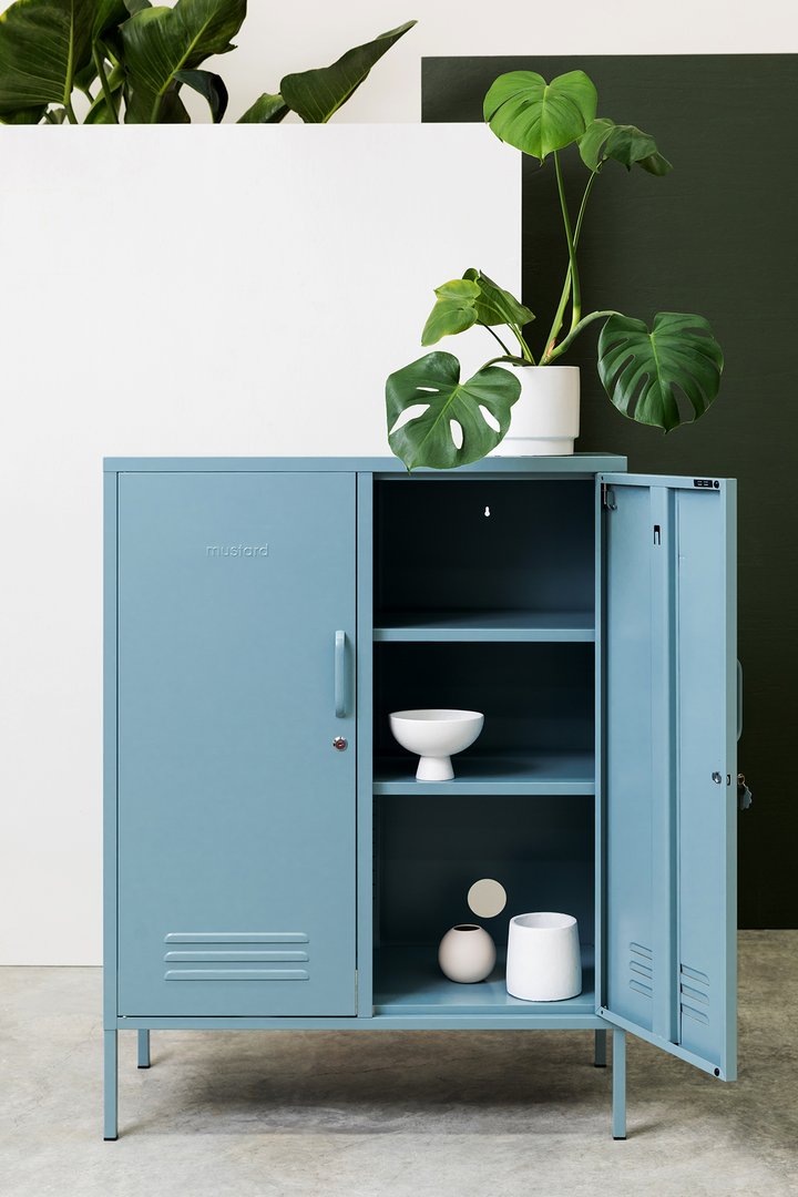 Mustard Made The Midi Locker in ocena blue with a plant ontop and white objects inside 