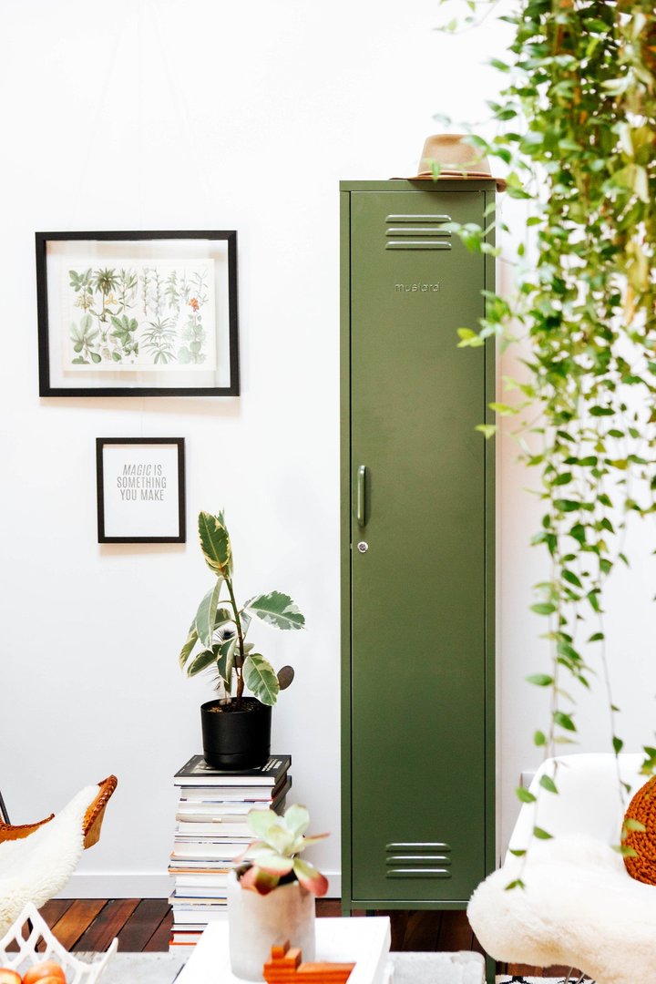Mustard Made The Skinny Locker in green beside foliage in a homely room