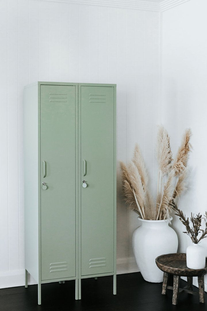 Mustard Made The Skinny Locker in sage two side by side beside foliage 