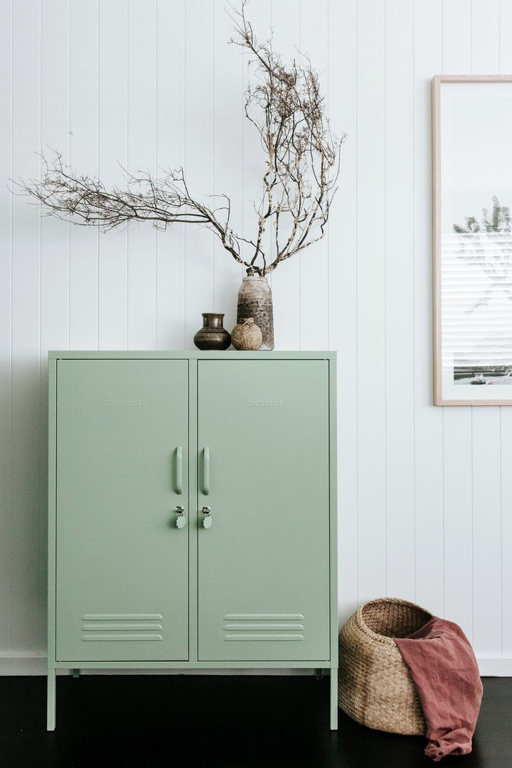 Mustard Made The Midi Locker in sage beside a basket with plant on top